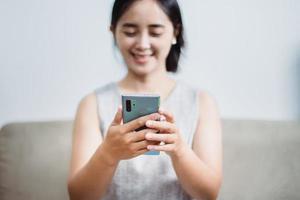 mujeres que operan teléfonos móviles en sofás, teléfonos inteligentes foto