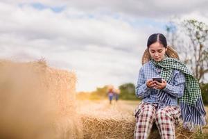 mujer agricultora que usa tecnología móvil en el campo de arroz foto