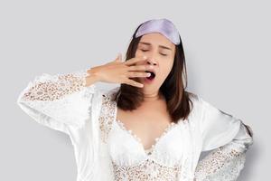 Woman yawning covering open mouth with hand need wake up photo