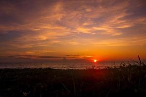 puesta de sol escénica en la playa con cielo brillante foto