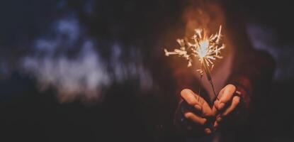 mano femenina disfruta con una explosión de bengala ardiente en la fiesta de año nuevo foto