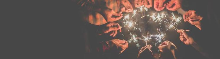 Group of young friends enjoy with burning sparkler in hands together photo