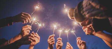 Group of young friends enjoy with burning sparkler in hands together photo