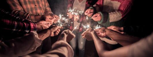 fuegos artificiales quemando bengala en manos humanas en la noche de fiesta de año nuevo foto