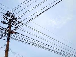 Electrical power junction at the pole reveals the complexity with the bright blue sky clouds photo