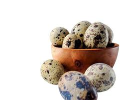 Quail eggs from quail, a collection of quail eggs on a wooden plate with isolated white background photo