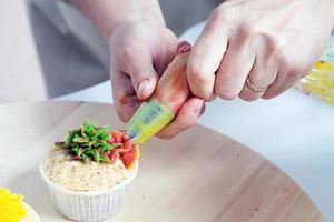 confectioner decorates  cupcake photo