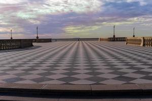 Livorno,Italy-november  27, 2022-people strolling on the Mascagni terrace, a splendid belvedere terrace with checkerboard paved surface, Livorno, Tuscany, Italy during a sunny day. photo