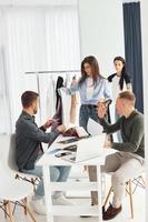 grupo de personas trabaja en la oficina sentándose junto a la mesa foto