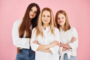 posando para una cámara. la joven madre con sus dos hijas está en el estudio foto