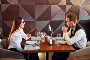 Young boyfriend with adult woman. Indoors of new modern luxury restaurant photo