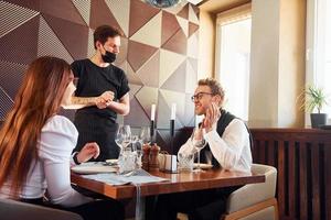 Young boyfriend with adult woman. Indoors of new modern luxury restaurant photo