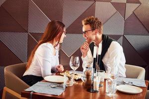 Young boyfriend with adult woman. Indoors of new modern luxury restaurant photo