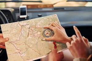 leyendo el mapa. una pareja joven viaja juntos por el bosque durante el día foto