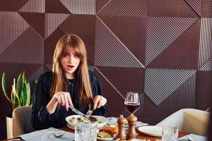 Girl tastes food. Indoors of new modern luxury restaurant photo