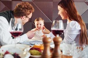 Young guy, woman and little boy. Indoors of new modern luxury restaurant photo