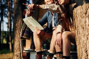 Weekend activities. Young couple is traveling in the forest at daytime together photo