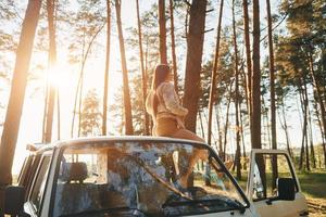 White bus. Woman is traveling alone in the forest at daytime at summer photo