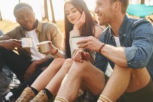 Talking with each other. Group of young people is traveling together in the forest at daytime photo