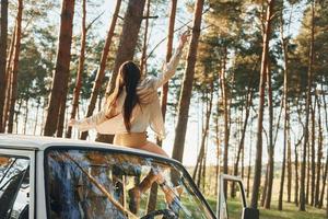 White bus. Woman is traveling alone in the forest at daytime at summer photo