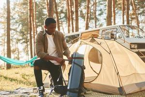 African american man is traveling alone in the forest at daytime at summer photo