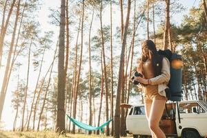 Warm sunlight. Woman is traveling alone in the forest at daytime at summer photo