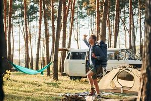 Looks at location. Man is traveling alone in the forest at daytime at summer photo