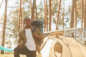 With mat near car. Man is traveling alone in the forest at daytime at summer photo