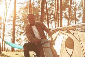 Positive emotions. Man is traveling alone in the forest at daytime at summer photo