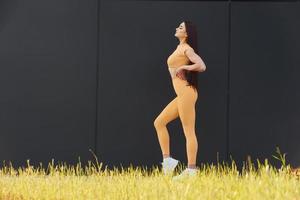 césped verde. mujer joven en ropa deportiva tiene sesión de fitness al aire libre foto