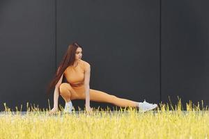 césped verde. mujer joven en ropa deportiva tiene sesión de fitness al aire libre foto