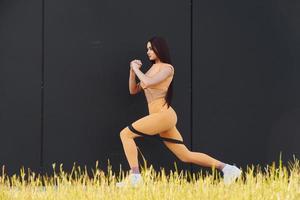 rutina diaria de fitness. mujer joven en ropa deportiva haciendo ejercicios al aire libre foto