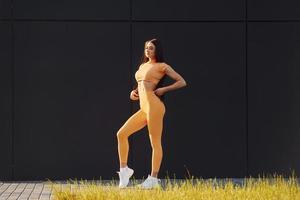 estilo de vida saludable. mujer joven en ropa deportiva tiene sesión de fitness al aire libre foto