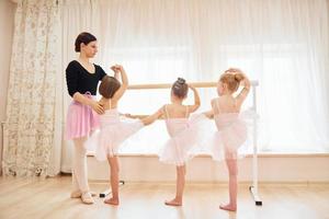 pequeñas bailarinas preparándose para la actuación practicando movimientos de baile foto