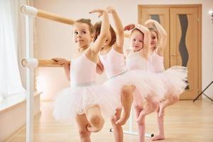 pequeñas bailarinas preparándose para la actuación practicando movimientos de baile foto