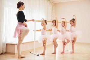 Practicing pose. Little ballerinas preparing for performance photo