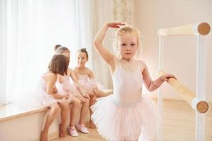 pequeñas bailarinas con uniformes rosas preparándose para la actuación foto