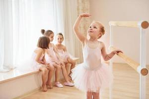 pequeñas bailarinas con uniformes rosas preparándose para la actuación foto