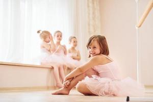 practicando en el suelo. pequeñas bailarinas preparándose para la actuación foto