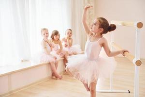 pequeñas bailarinas con uniformes rosas preparándose para la actuación foto