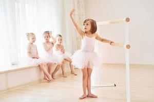 Practicing dance moves. Little ballerinas preparing for performance photo