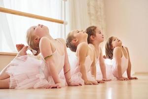 ejercicios de estiramiento. pequeñas bailarinas preparándose para la actuación foto