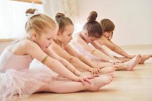Stretching exercises. Little ballerinas preparing for performance photo