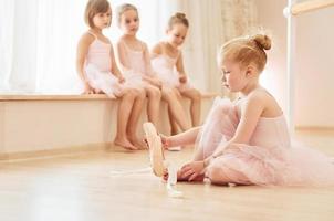 pequeñas bailarinas con uniformes rosas preparándose para la actuación foto