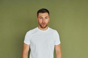 joven con camisa blanca de pie en el interior del estudio foto