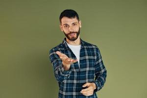 Young man in casual clothes standing indoors in the studio photo