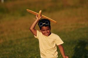 Weekend activities. African american kid have fun in the field at summer daytime photo