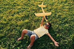 Beautiful summer daytime. African american kid have fun on the field photo