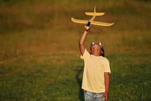 Retro style pilot sunglasses. African american kid have fun in the field at summer daytime photo