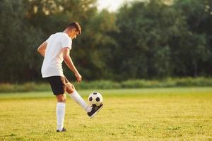 Summer daytime. Young soccer player have training on the sportive field photo